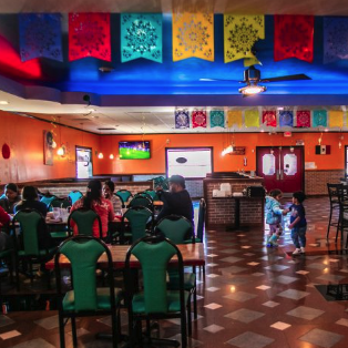 The warm, family-friendly dining room with papel picado at El Paisano Mexican Food and Bakery in Des Moines