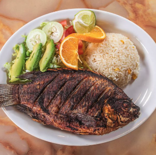 Whole grilled mojarra fish with rice and salad at El Paisano Mexican restaurant in Des Moines